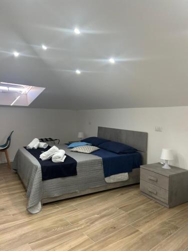 a bedroom with a bed with blue sheets and a table at GIULY SUITES & ROOMS in Naples