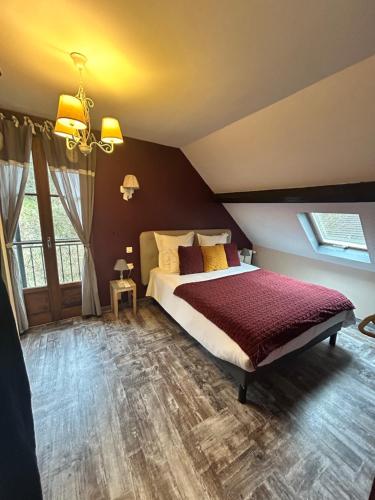 a bedroom with a large bed in a room at Le D'Tour Gourmand in Toulouse-le-Château