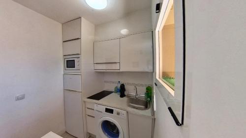 a small kitchen with a sink and a washing machine at Residencial Las Dunas, Best Holiday Home Resort On The Island- VV in Corralejo