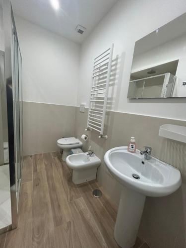 a white bathroom with a sink and a toilet at GIULY SUITES & ROOMS in Naples