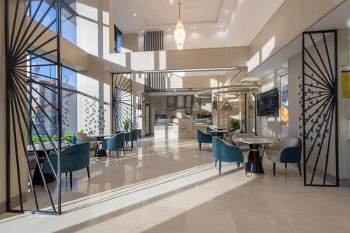a lobby with blue chairs and tables in a building at Tara Plus Hotel in Jeddah