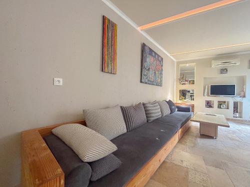 a living room with a couch with pillows at Studio d'artiste climatisée, proche plage in Fréjus