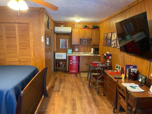 a small bedroom with a bed and a kitchen at Mountain Aire Cottages, Inn, & Glamping in Clayton