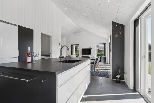 a kitchen with white cabinets and a black counter top at Ferie-Oasen i Øster Hurup in Øster Hurup