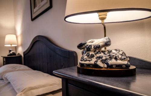 a lamp on a table next to a bed at Tenuta di Paganico - I Roggeti in Paganico