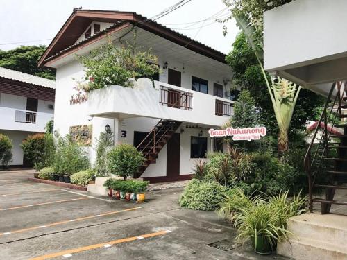 a building with a balcony with plants on it at Baan Nuk Anong in Chiang Rai