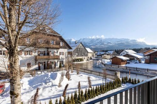 a village in the snow with mountains in the background at Alpine Suite Spot in Bad Mitterndorf