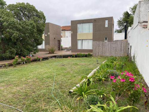 un patio con bancos y flores frente a un edificio en Duplex Rio Uruguay 161, en Monte Hermoso