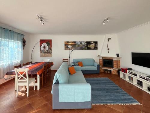 a living room with a couch a table and a television at Casa Campo e Praia by DolceStay - V4 no Meco a 5min da Praia com Jardim & BBQ in Sesimbra