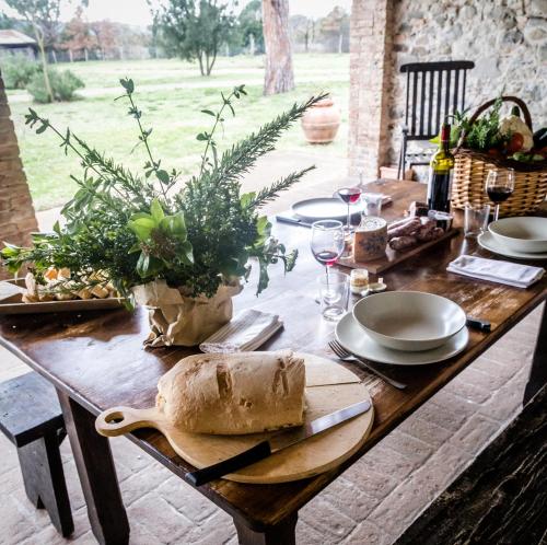a wooden table topped with a table with bread on it at Tenuta di Paganico - I Roggeti in Paganico