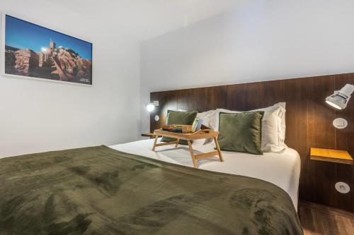 a bedroom with a large bed with a wooden headboard at Quinta Pedra Firme in Sintra