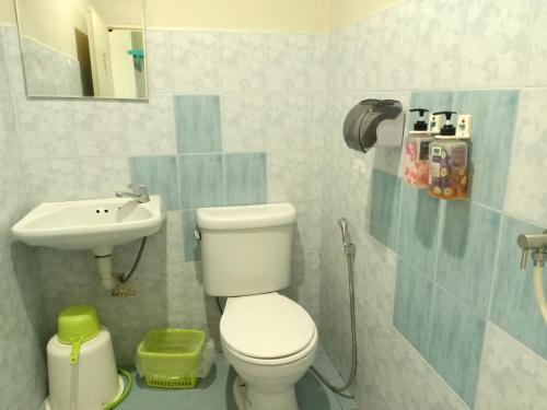 a bathroom with a toilet and a sink at Baan Nuk Anong in Chiang Rai