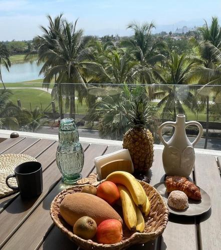 a basket of fruit on a table with a view at Departamento en Nuevo Vallarta in Nuevo Vallarta
