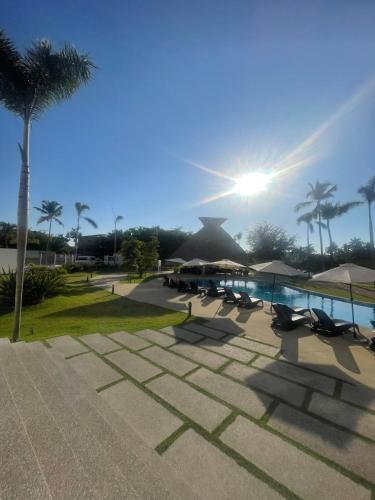 a pool with chairs and umbrellas in a resort at Departamento en Nuevo Vallarta in Nuevo Vallarta
