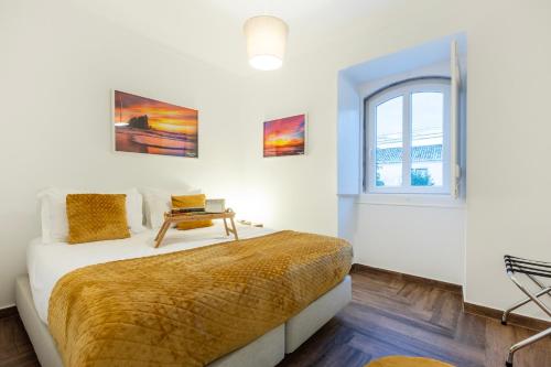 a white bedroom with a bed and a window at Quinta Pedra Firme in Sintra