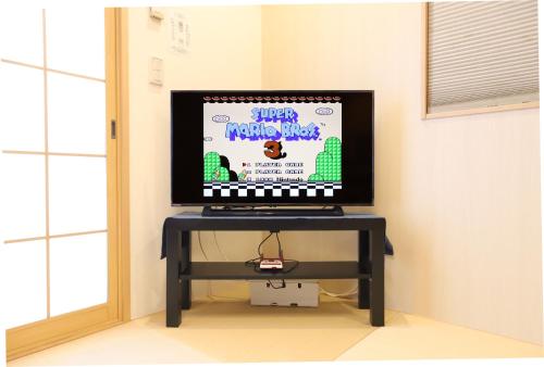 a television sitting on a table with a keyboard at 一棟貸切り宿 GuestHouse 嵯峨嵐山 in Kyoto