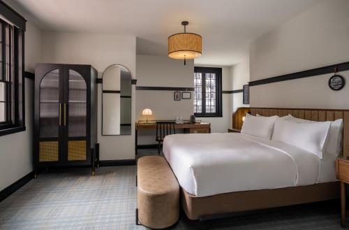 ein Schlafzimmer mit einem großen weißen Bett und einem Schreibtisch in der Unterkunft Visitation Hotel Fredrick, a Tribute Portfolio Hotel in Frederick