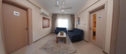 a living room with a blue couch and a table at Grand Orchid Hotel Apartment in Duqm