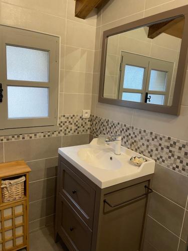 un baño con lavabo y espejo en Maison pierre avec piscine privée, en Blanquefort-sur-Briolance