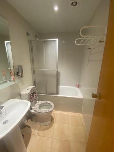 Un baño con inodoro, lavabo y ducha. en Gran Reserva 24, en Empuriabrava