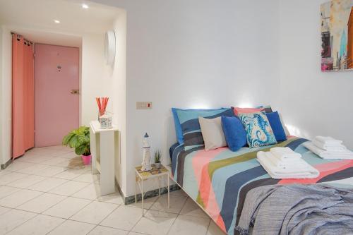 una camera da letto con un letto con cuscini colorati di OASI VIAREGGINA 700m Beach - Free WiFi - AC a Viareggio