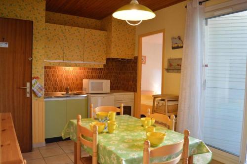 une cuisine avec une table et des chaises vertes dans l'établissement Appartement 2 pièces 4 couchages ARGELES SUR MER AR450-0407, à Argelès-sur-Mer