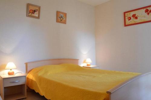 - une chambre avec un lit jaune et 2 tables de chevet dans l'établissement Appartement 2 pièces 4 couchages ARGELES SUR MER AR450-0407, à Argelès-sur-Mer