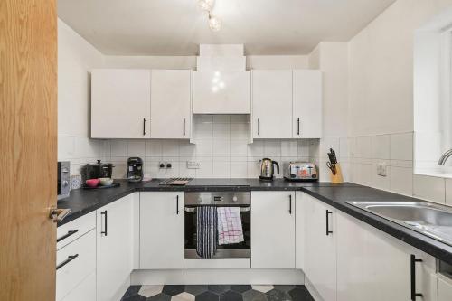 a white kitchen with white cabinets and a sink at 2-Bed 2 bath flat, Close to tube, Free Parking in London