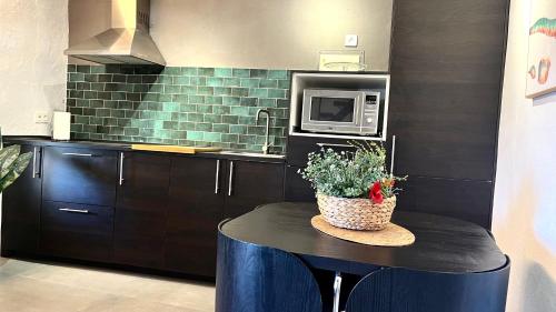 a kitchen with a table with a microwave and a counter at La Martela de Fuentes Casa de diseño rural in Fuentes de León