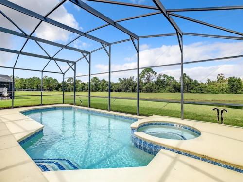 einen Blick über einen großen Pool mit einem großen Glasdach in der Unterkunft 7BR Villa in Emerald Island w/ Resort Perks in Kissimmee