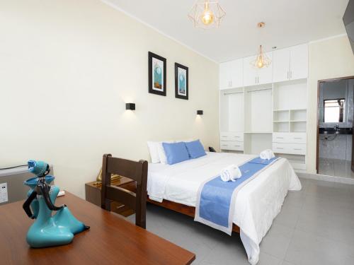 a bedroom with a bed and a wooden table at Hotel San Marino Tarapoto in Tarapoto
