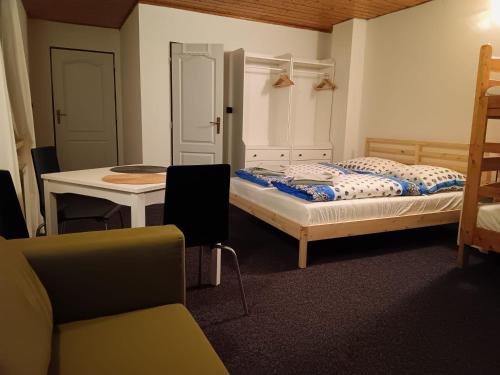 a room with two beds and a table and a desk at Vila Pramínek, Horní Maršov, Krkonoše in Horní Maršov