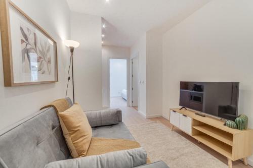 a living room with a couch and a television at Yellow Charm - Campolide Apartments in Lisbon