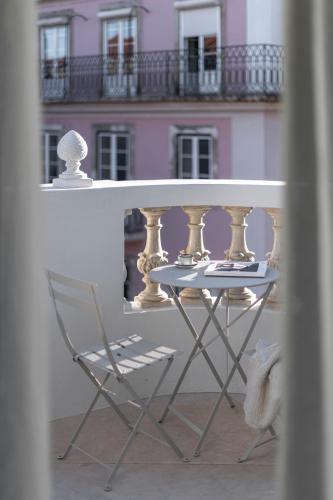 a table and a chair in front of a building at Montecarmo12 - Design Boutique Hotel in Lisbon