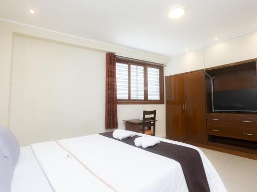 a bedroom with a bed and a flat screen tv at Hotel San Marino Tarapoto in Tarapoto