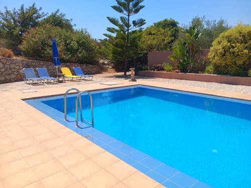a swimming pool with blue water in a yard at Secluded Villa with Private Pool Almyrida in Almirida