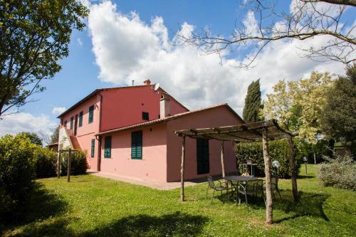 a pink house with a table in front of it at Tenuta di Paganico - I Roggeti in Paganico
