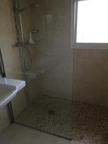 une salle de bain avec une douche avec une porte vitrée dans l'établissement Villa Saint-Aygulf, à Saint-Aygulf