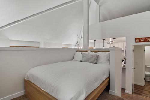 a white bedroom with a large bed with white sheets at Hidden Creek by Park City Vacations in Park City