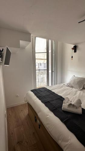 une chambre avec un grand lit avec une grande fenêtre dans l'établissement Appartement 2 pieces centre Menton jardin Bioves, à Menton