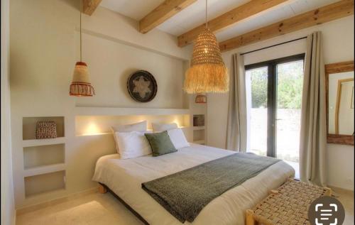 - une chambre avec un lit, une fenêtre et des lampes pendant dans l'établissement Bonifacio Maison 6 personnes Piscine Chauffée, à Bonifacio