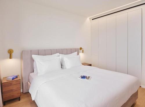 a bedroom with a large white bed with white pillows at Petram Resort & Residences in Savudrija