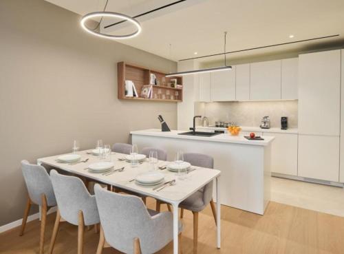 a kitchen and dining room with a white table and chairs at Petram Resort & Residences in Savudrija