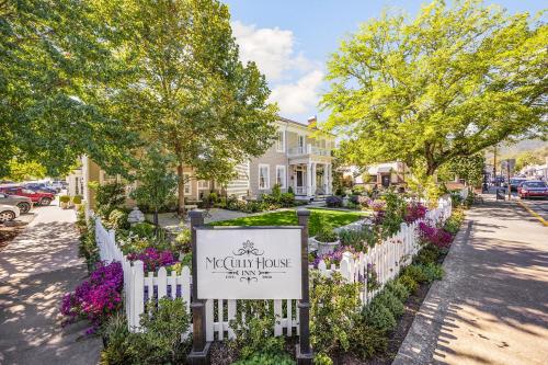 a white picket fence with a sign in front of a house at McCully House Inn in Jacksonville