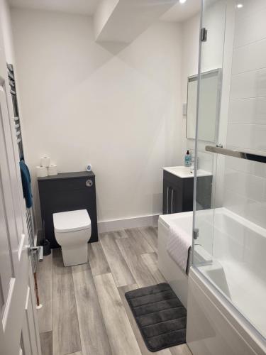 a white bathroom with a toilet and a sink at Seaside 3 Bedroom Home in Ramsgate