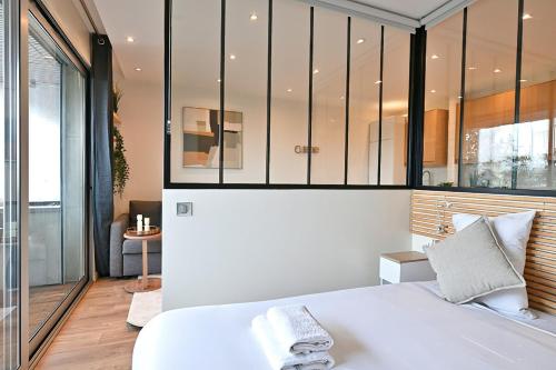 une chambre avec un grand lit blanc dans une pièce dans l'établissement Charming apartment Neuilly-sur-seine, à Neuilly-sur-Seine