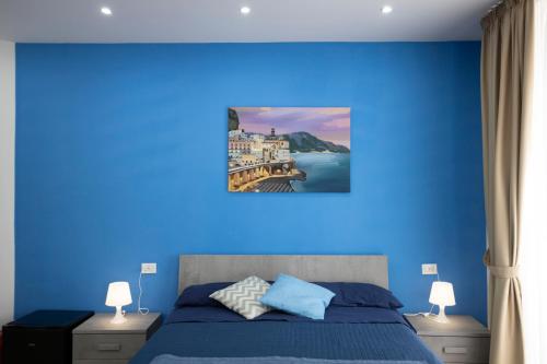 a blue bedroom with a bed with a blue wall at GIULY SUITES & ROOMS in Naples