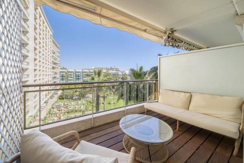un balcon avec un canapé et une table dans l'établissement REF 1512 - Cannes Croisette, à Cannes