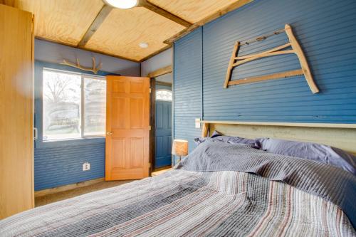 a bedroom with a blue wall and a bed at Quaint Ironton Getaway with Fire Pit, Gas Grill! in Ironton