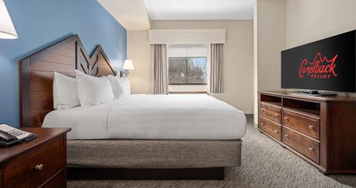 a hotel room with a large bed and a television at Camelback Resort in Tannersville